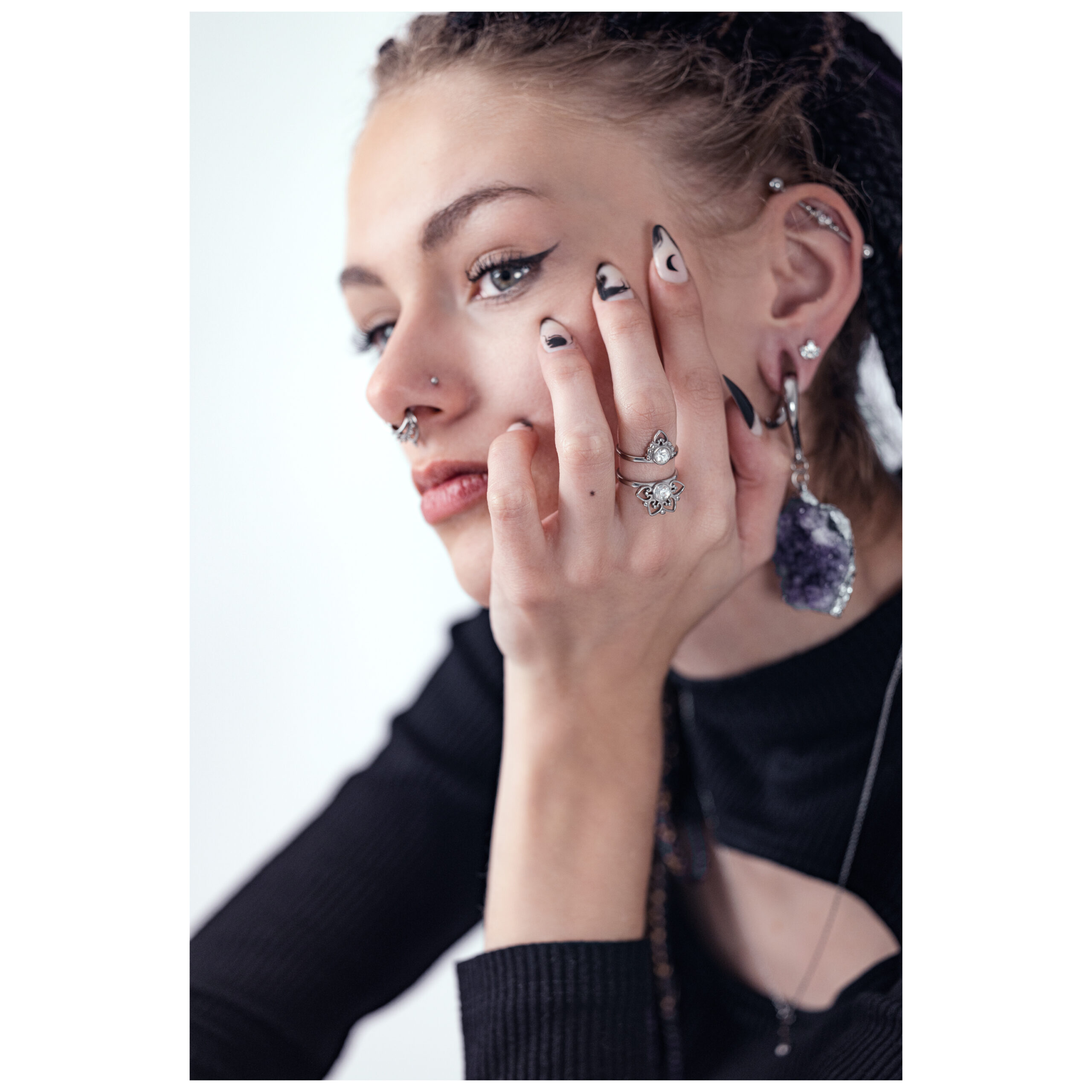 Frau mit Silberring Silver Sun Tides, Hand am Gesicht, schwarzes Oberteil