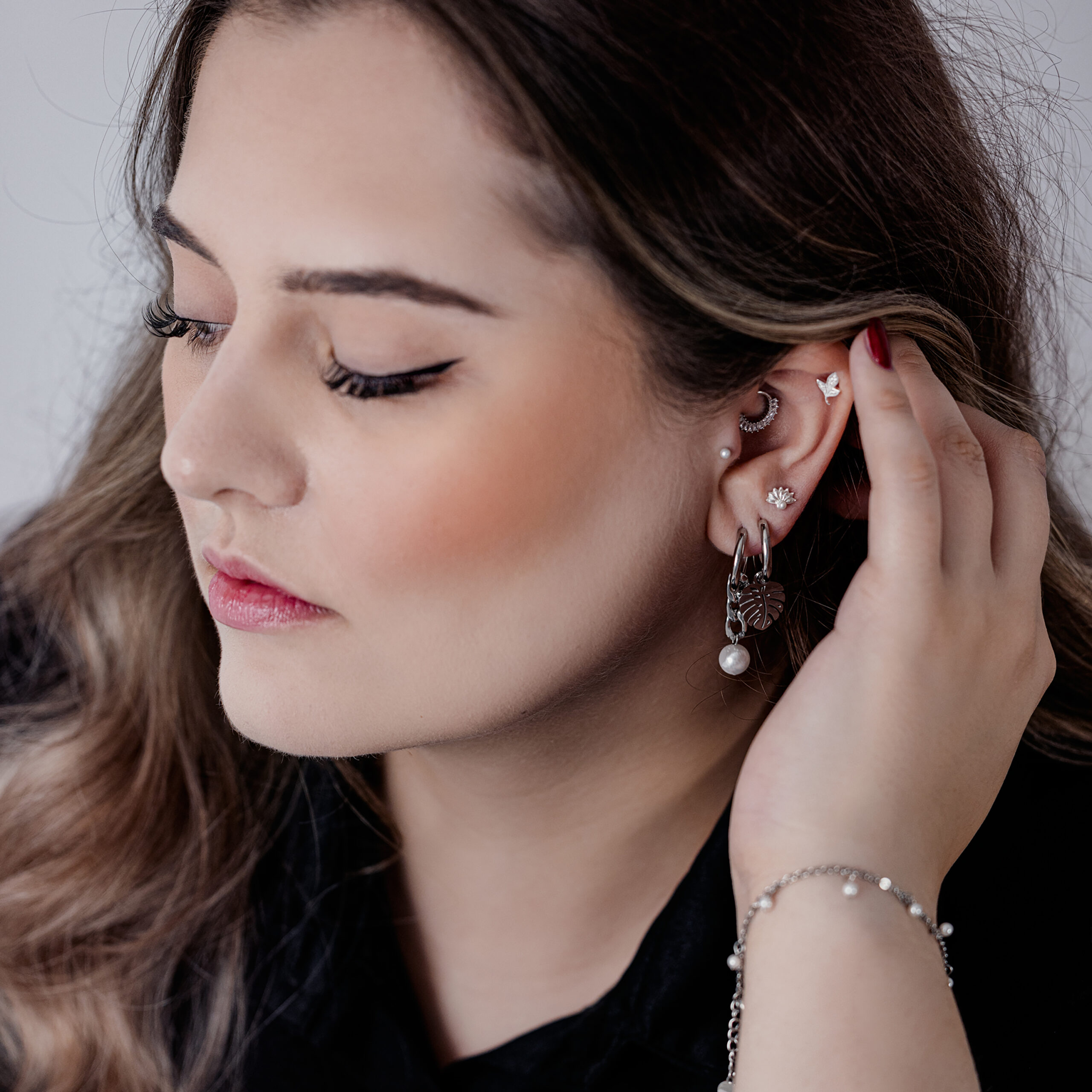 Frau mit Monstera Ohrringen aus Edelstahl, silberne Farbe, seitliche Ansicht