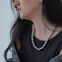 Frau trägt silberne Bubble Kette aus Chirurgenstahl mit schwarzem Oberteil