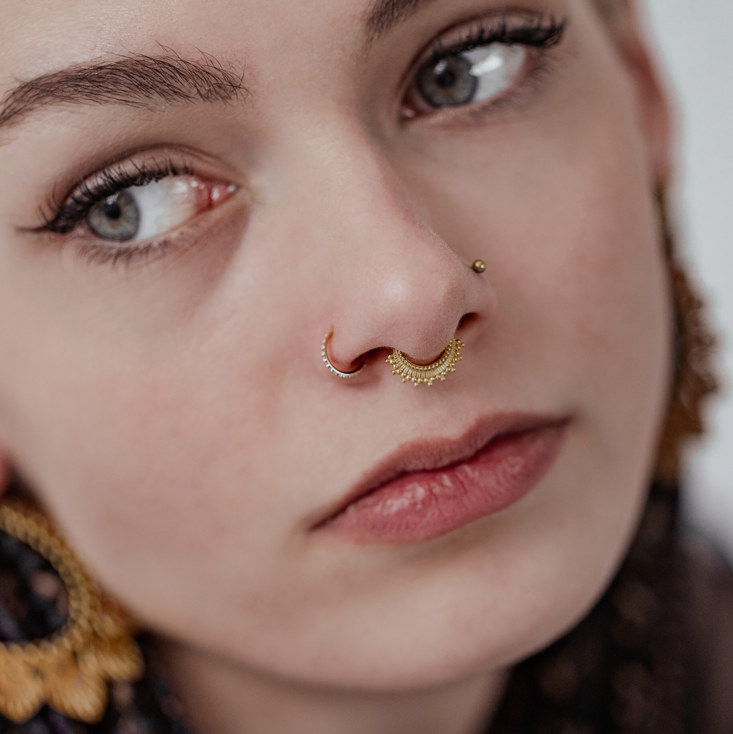 Frau mit goldenem Conch Ring und weißen Kristallen, Nahaufnahme