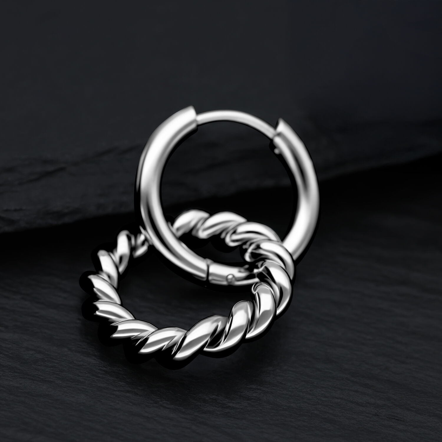 Silberne Twisted Circle Hoops aus Edelstahl auf schwarzem Hintergrund