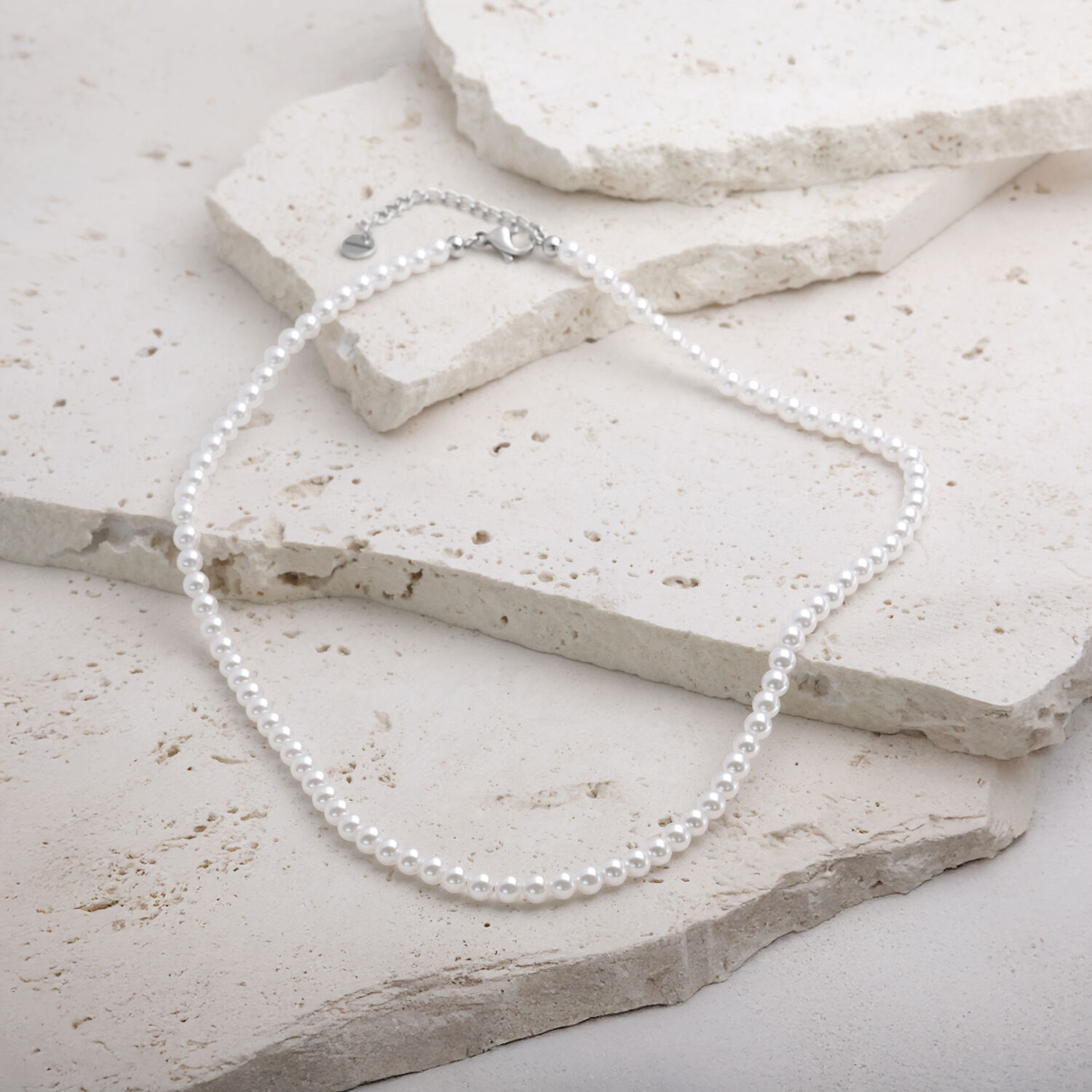 Synthetische Perlenkette aus Chirurgenstahl auf hellem Stein