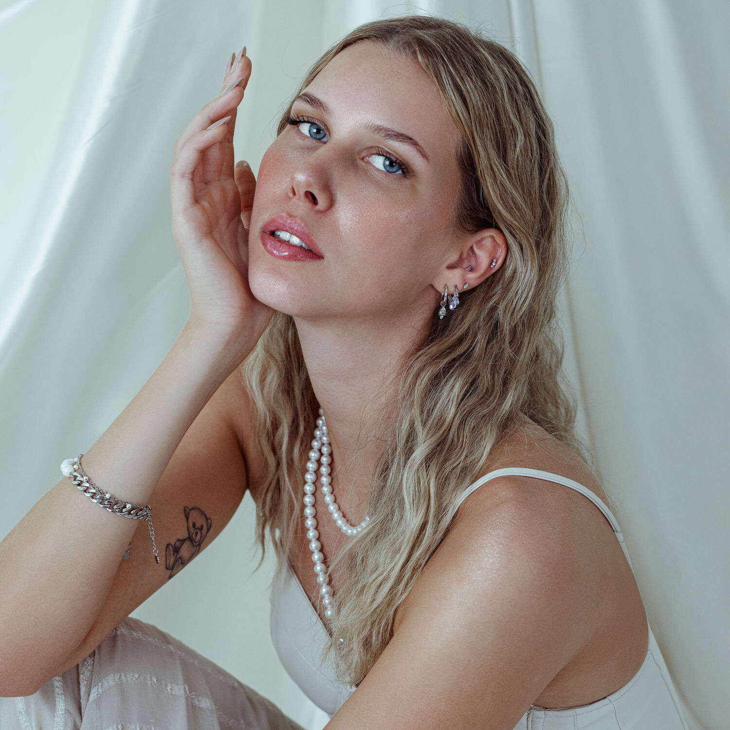 Frau mit Push Fit Kristallaufsatz in Lavendel am Ohr vor weißem Hintergrund