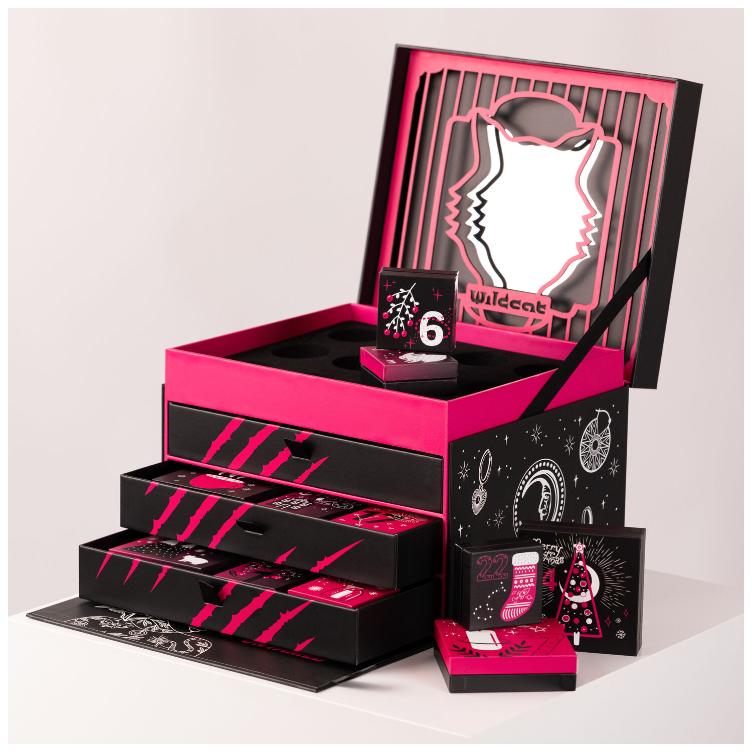 Wildcat Adventskalender 2025 - Schwarz Schwarzer Wildcat Adventskalender mit offenen Schubladen und pinken Akzenten auf weißem Hintergrund