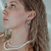 Frau mit silbernen Ohrpiercings und Kristallen, Nahaufnahme