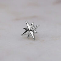 Sternförmiger Push Fit Aufsatz aus Titan Silberner sternförmiger Aufsatz aus Titan auf hellem Hintergrund