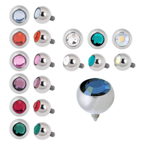Silberne Piercing-Aufsätze mit bunten Kristallen auf weißem Hintergrund