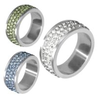 Drei Ringe aus silbernem Chirurgenstahl mit klaren, hellblauen und hellgrünen Kristallen vor weißem Hintergrund