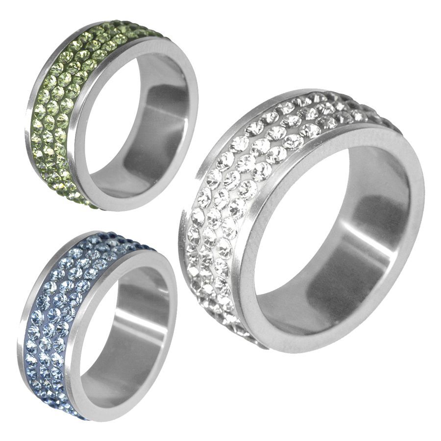 Drei Ringe aus silbernem Chirurgenstahl mit klaren, hellblauen und hellgrünen Kristallen vor weißem Hintergrund