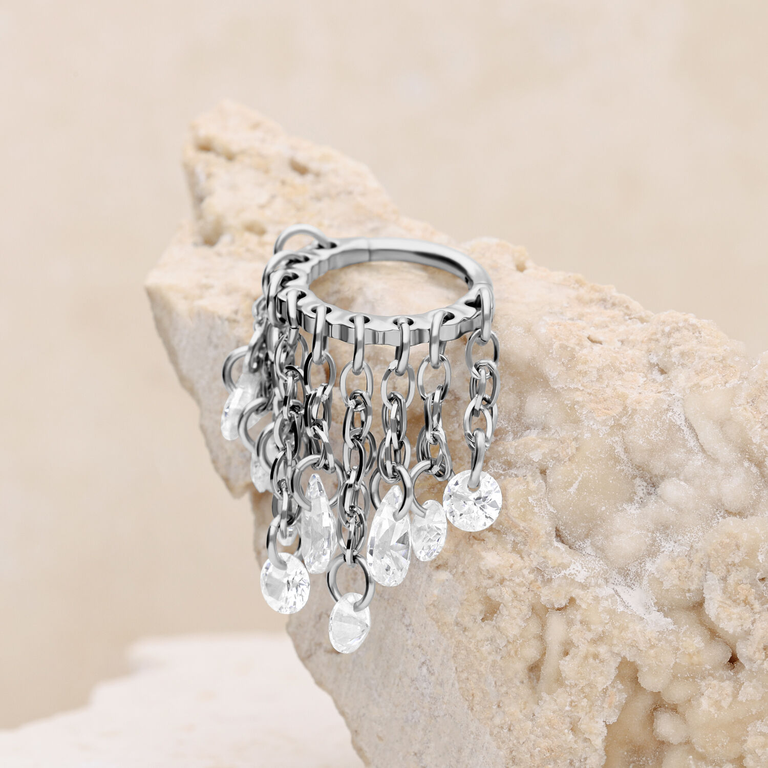 Silberner Waterfall Crystal Clicker mit klaren Kristallen Silberner Piercingring mit klaren Kristallen auf hellem Stein