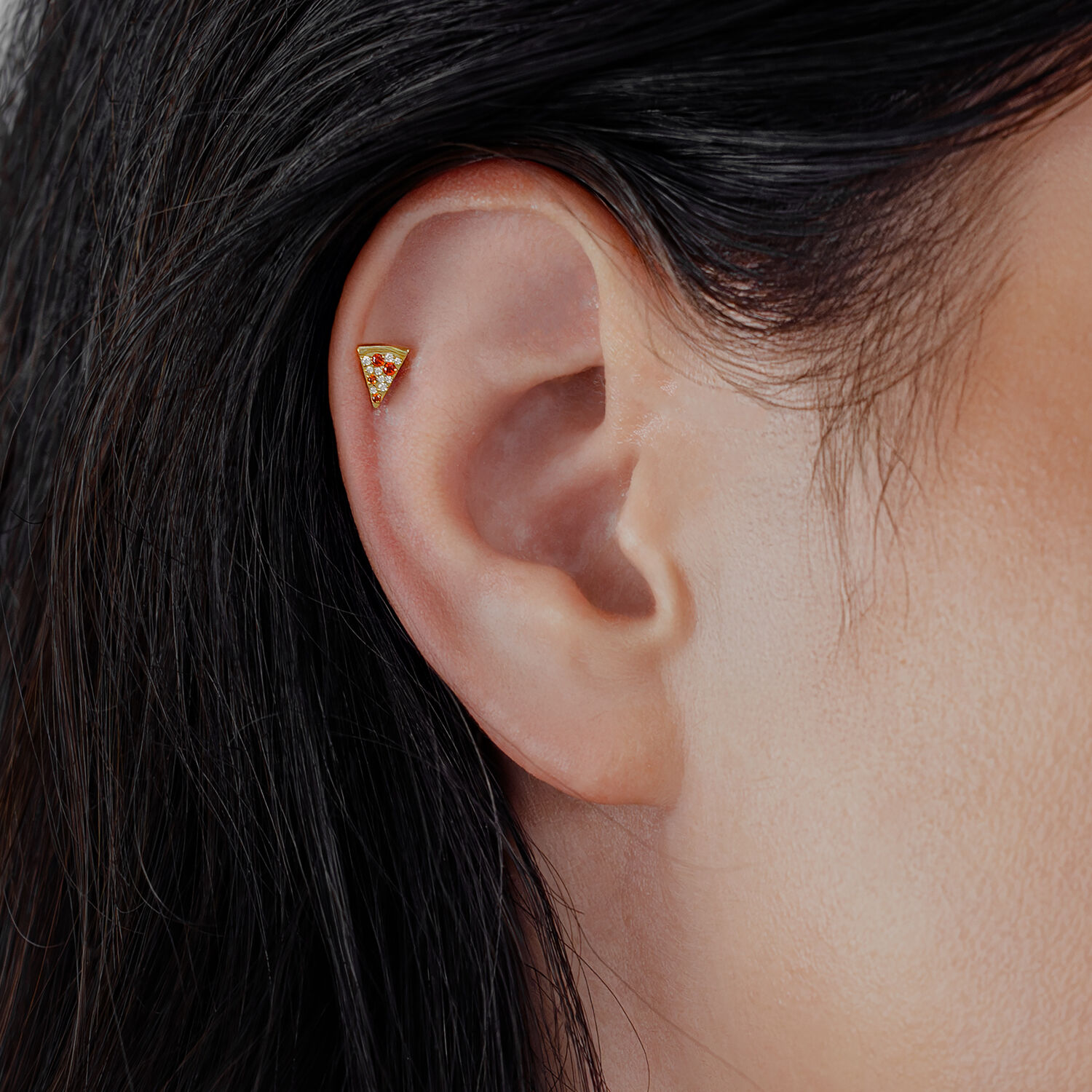 Goldener Pizza-förmiger Aufsatz im Ohr, klare Kristalle, glänzendes Titan.