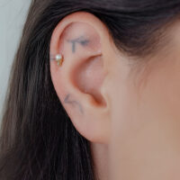 Goldener Titan Push Fit Aufsatz mit kristallklarem Kristall im Ohr getragen.