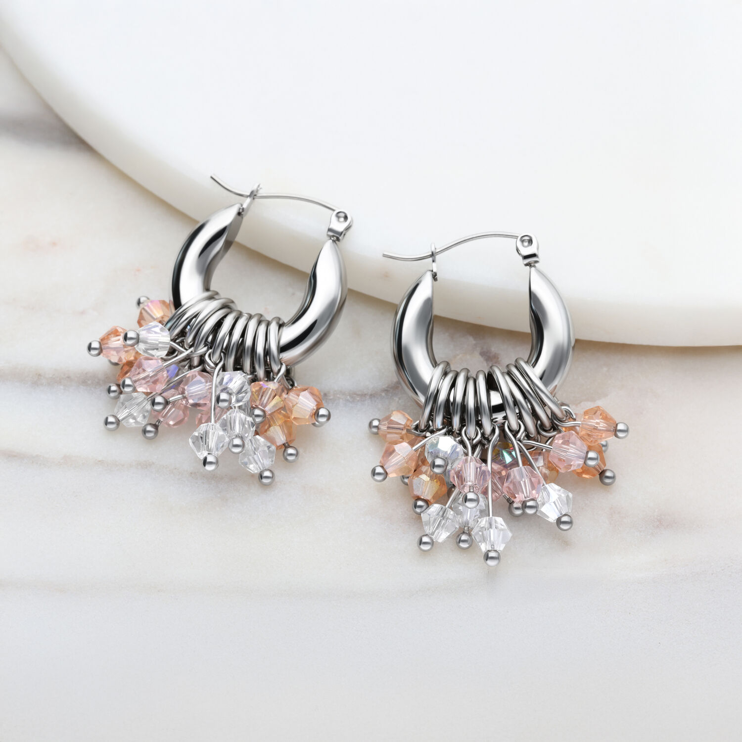 Glamour Hoops in Silber mit Kristallanhängern Silberne Creolen mit bunten Kristallanhängern auf hellem Hintergrund