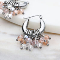 Glamour Hoops Ohrringe in Silber mit Kristallen Silberne Glamour Hoops Ohrringe mit bunten Kristallen auf marmoriertem Hintergrund