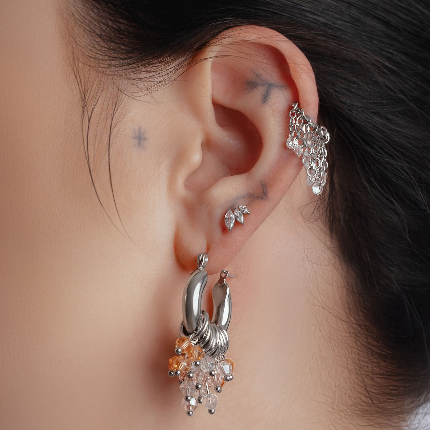 Glamour Hoops in Silber und Gold am Ohr Silberne und goldene Glamour Hoops am Ohr einer Person, Nahaufnahme