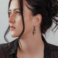 Glamouröse Creolen in Silber und Gold Frau mit glamourösen Creolen aus Silber und Gold, eleganter Look