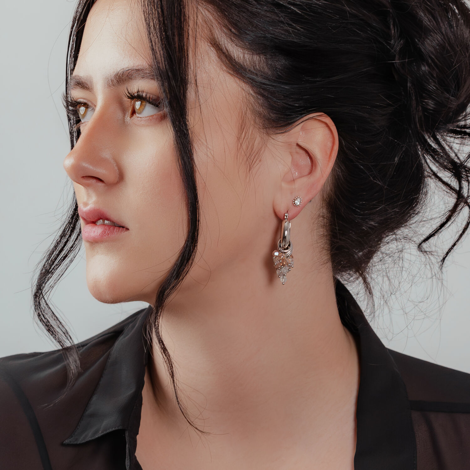 Glamouröse Creolen in Silber und Gold Frau mit glamourösen Creolen aus Silber und Gold, eleganter Look