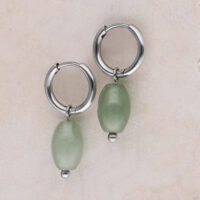 Zwei silberne Creolen mit grünen Aventurin-Anhängern auf hellem Hintergrund