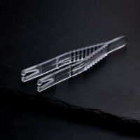 Klare sterile Triangel Piercingzange auf schwarzem Hintergrund, einzeln verpackt