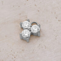 Silberner Kristall-Anhänger mit drei funkelnden Steinen auf hellem Hintergrund