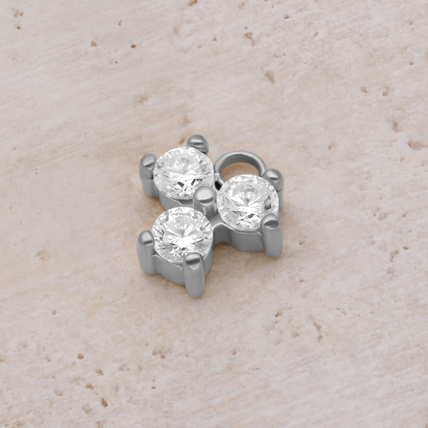 Silberner Kristall-Anhänger mit drei funkelnden Steinen auf hellem Hintergrund