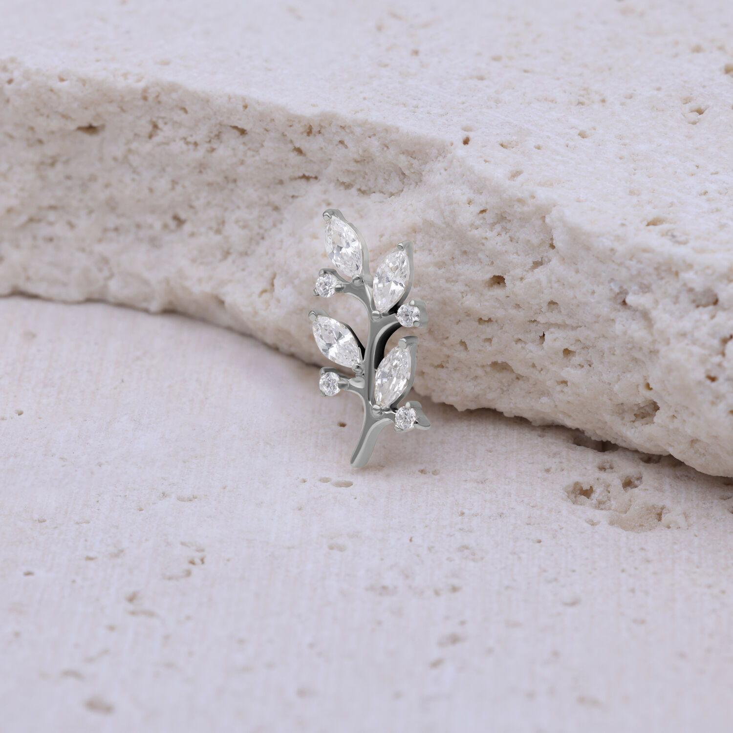 Silberner Kristallblatt-Aufsatz aus Titan vor hellem, strukturiertem Hintergrund