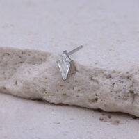 Kristallklarer Push Fit Aufsatz auf Stein Silberner Push Fit Aufsatz mit kristallklarem Stein auf beigem Hintergrund