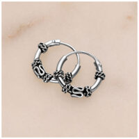 Silberne Creolen mit Knoten-Details auf hellem Hintergrund