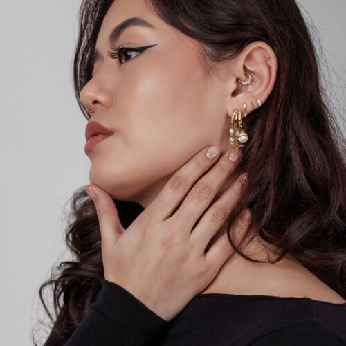 Frau mit goldenen Pearl Starlight Ohrsteckern, seitliches Profil