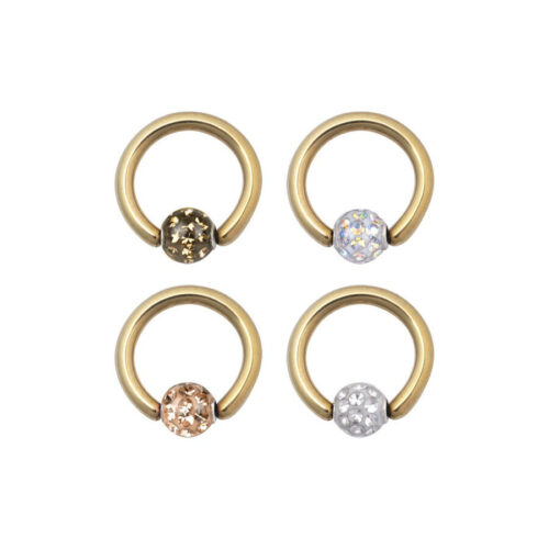 Vier goldene Clip in Ringe mit verschiedenfarbigen Kristallen auf weißem Hintergrund