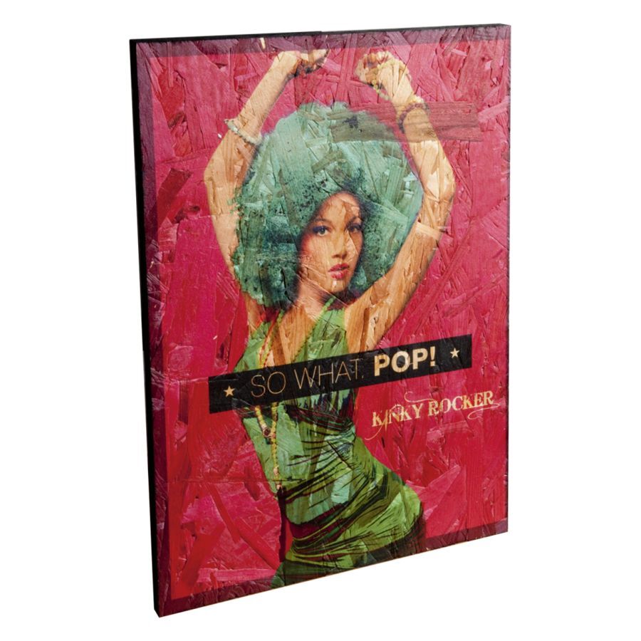 Holzschild mit grün gekleideter Frau und Schriftzug 'SO WHAT. POP!' auf rotem Hintergrund