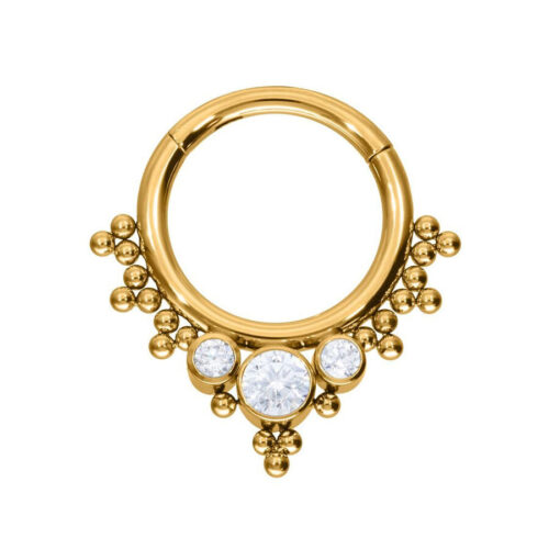 Goldener Piercingring mit drei klaren Kristallen auf weißem Hintergrund