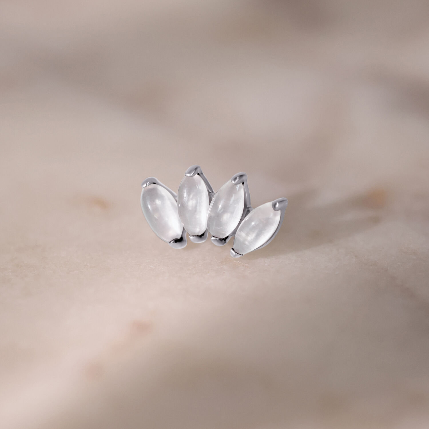 Vier silberne Mondstein-Aufsätze auf marmoriertem Hintergrund