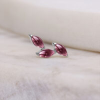 Silberner Push Fit Piercing Aufsatz mit Amethyst auf hellem Hintergrund