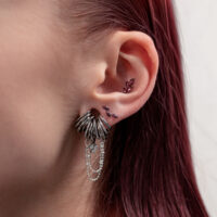 Ohr mit silbernem Titan-Piercing und Amethyststeinen, seitliche Ansicht